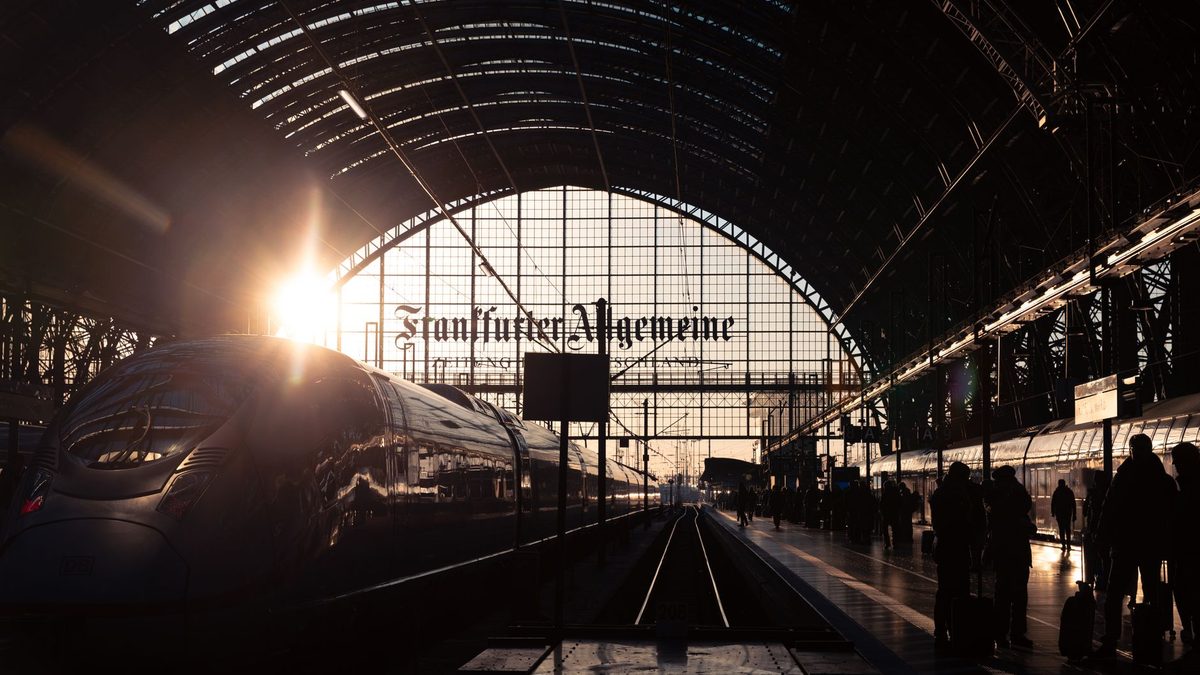 Beautiful sunset at Frankfurt's main train station with travelers and a modern train.
