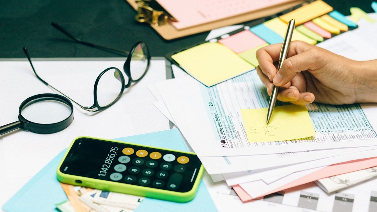 Close-up of an office desk with a calculator, glasses, and documents for financial planning.